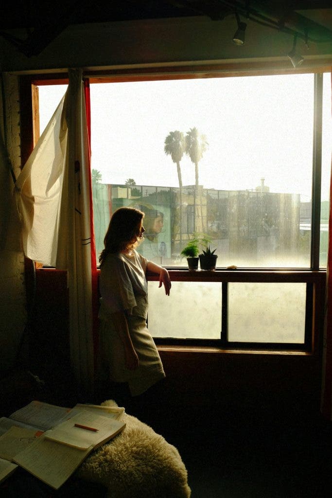 Portrait of a woman standing in front of a window A mist filter adds to the dreaminess.