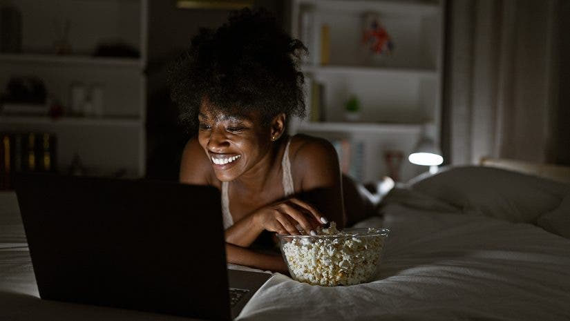woman lit by laptop screen with lamp behind her for practical use of lights via adobe stock.