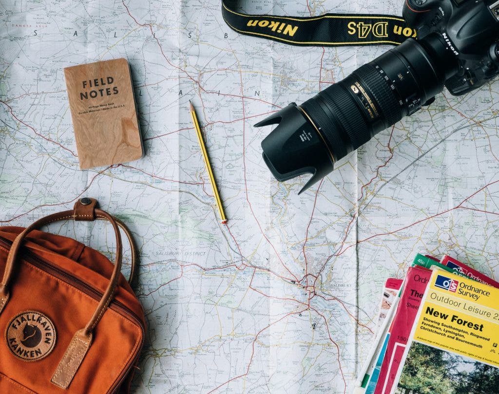 traveler's backpack with lens and map