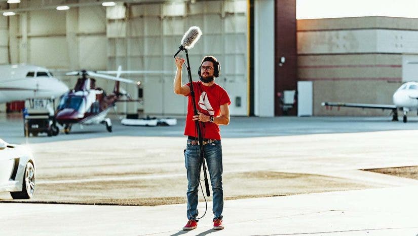 Man holding a boom microphone for video