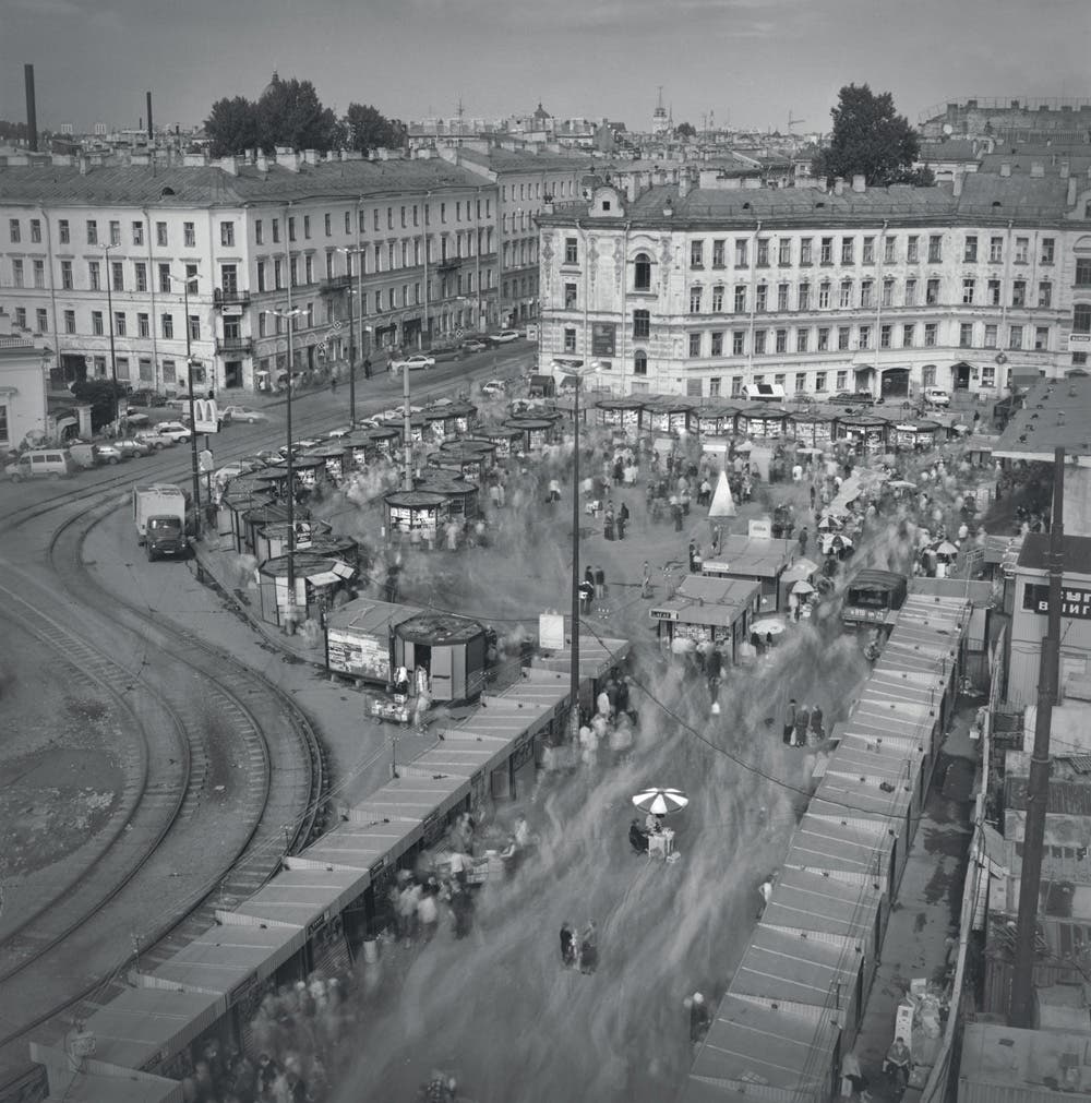 Black and white photo shows people gathered in town