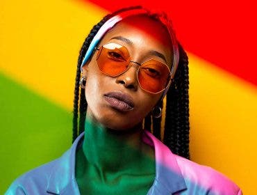 Beautiful afro-american woman with afro pigtails hairstyle and stylish clothes - Portrait of the young black girl in the studio - Color Gels