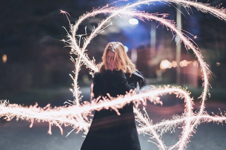 Girl poses with lighting fixture over high ISO and long shutter speed and wide aperture settings