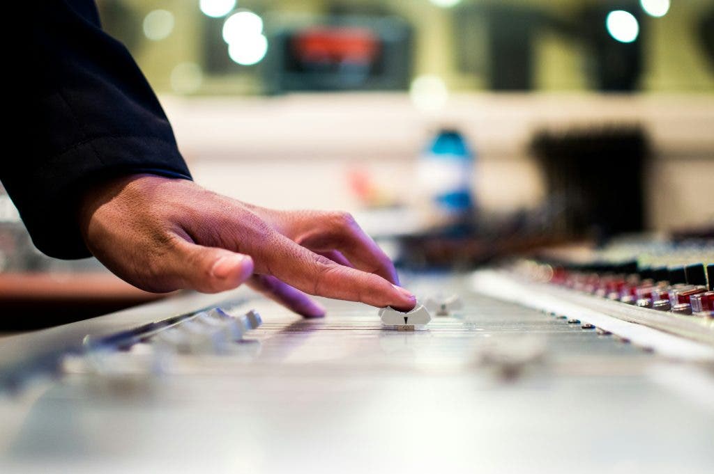 Hand of man who masters music in his studio