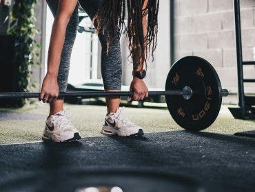 woman wearing a fitness tracker at the gym doing strength training