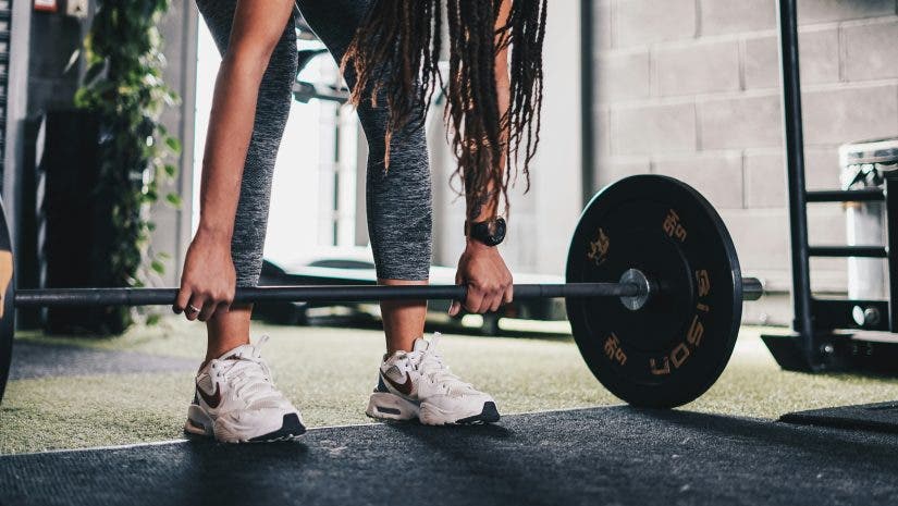 woman wearing a fitness tracker at the gym doing strength training