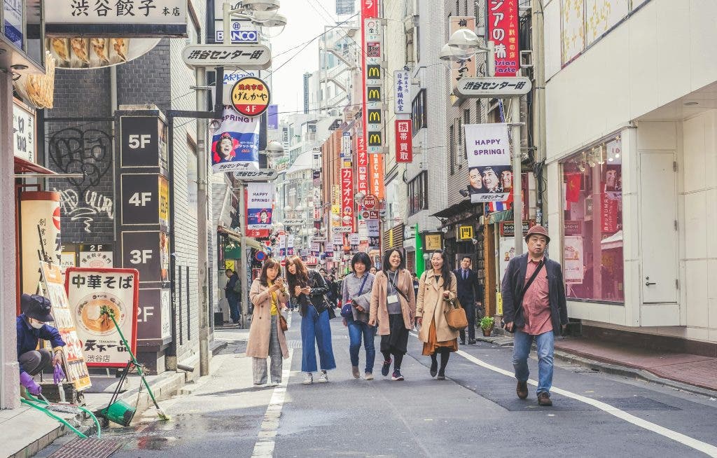 A group of people walk together down the streets of Japan