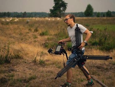 a man carrying gear as a camera assistant