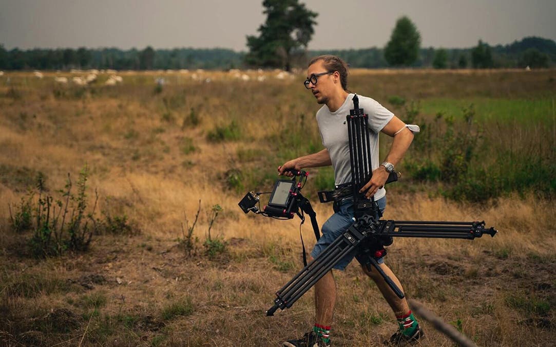 a man carrying gear as a camera assistant