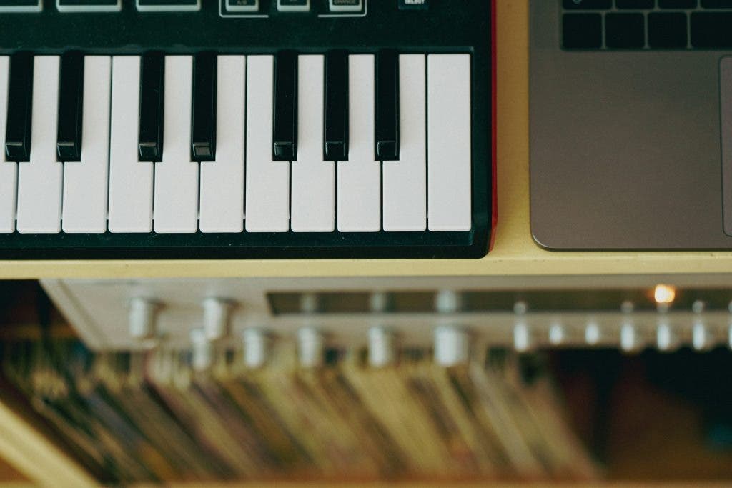 a photo of a keyboard beside a laptop researching the benefits of learning the keyboard