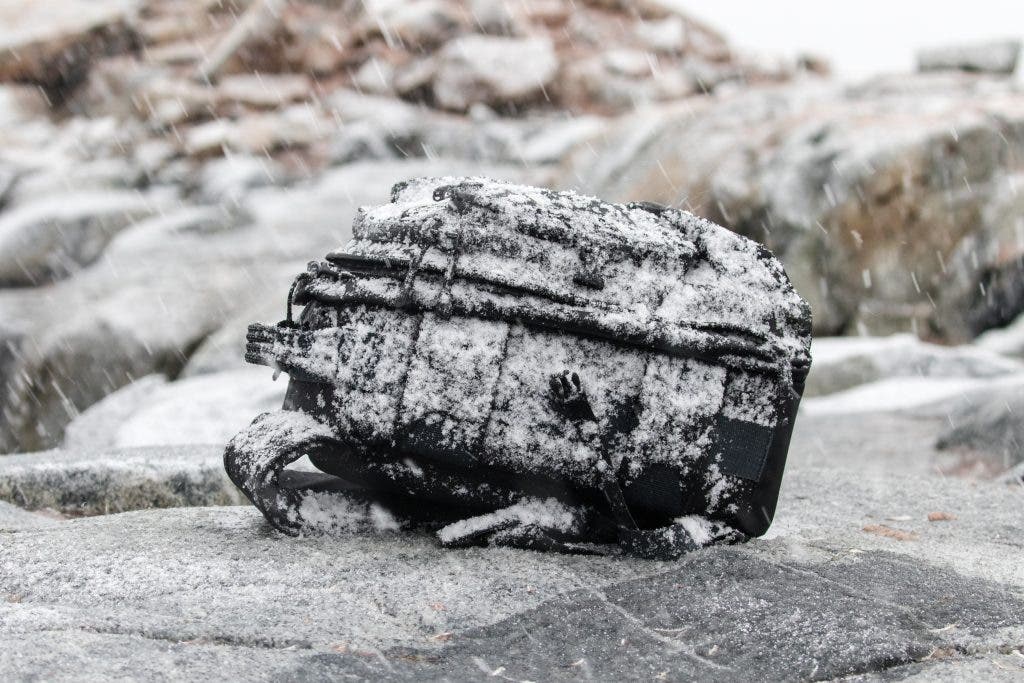 Photographers camera backpack in snow storm. Landscape photography gear.