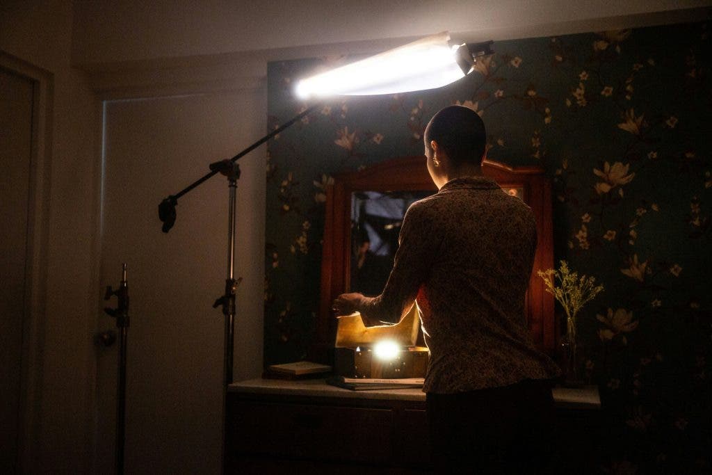 a camera assistant on set helping with lighting for a movie