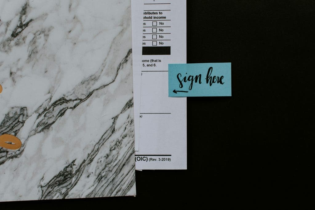 a talent release form with a "sign here" sticker