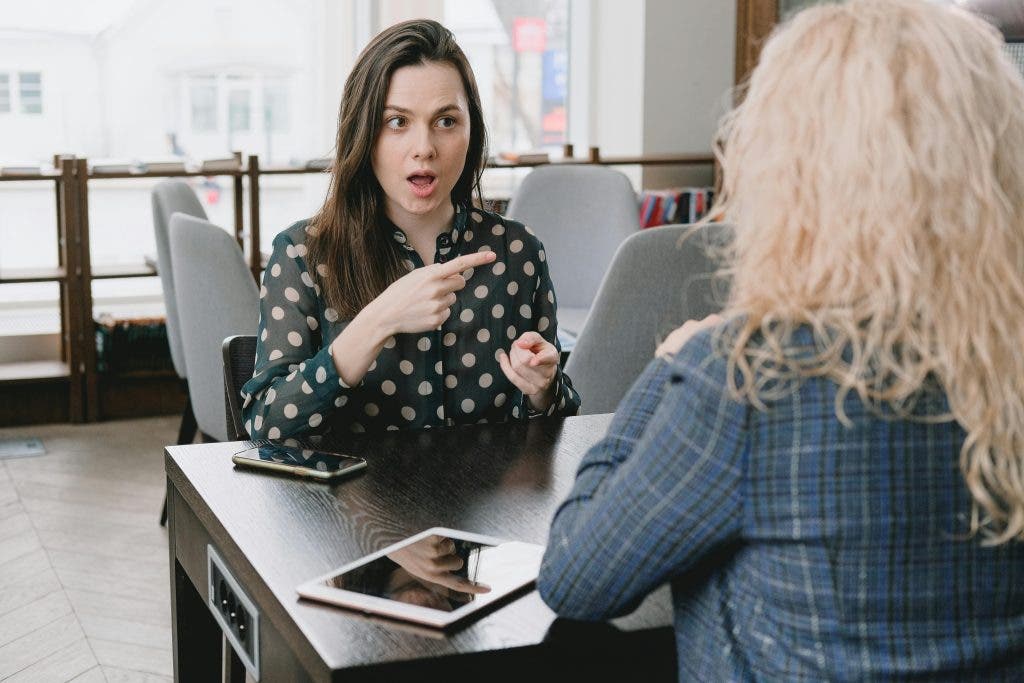a picture of two women having conversation at their office