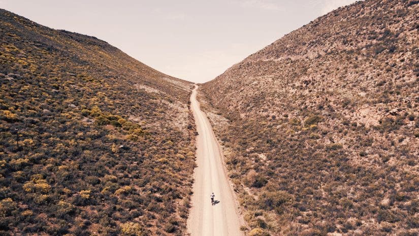 Endless roads, towering mountains, and one lone cyclist—captured from a perspective only a drone can reveal