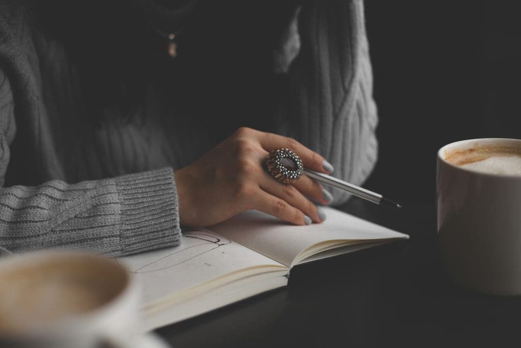a woman holding a pen and book