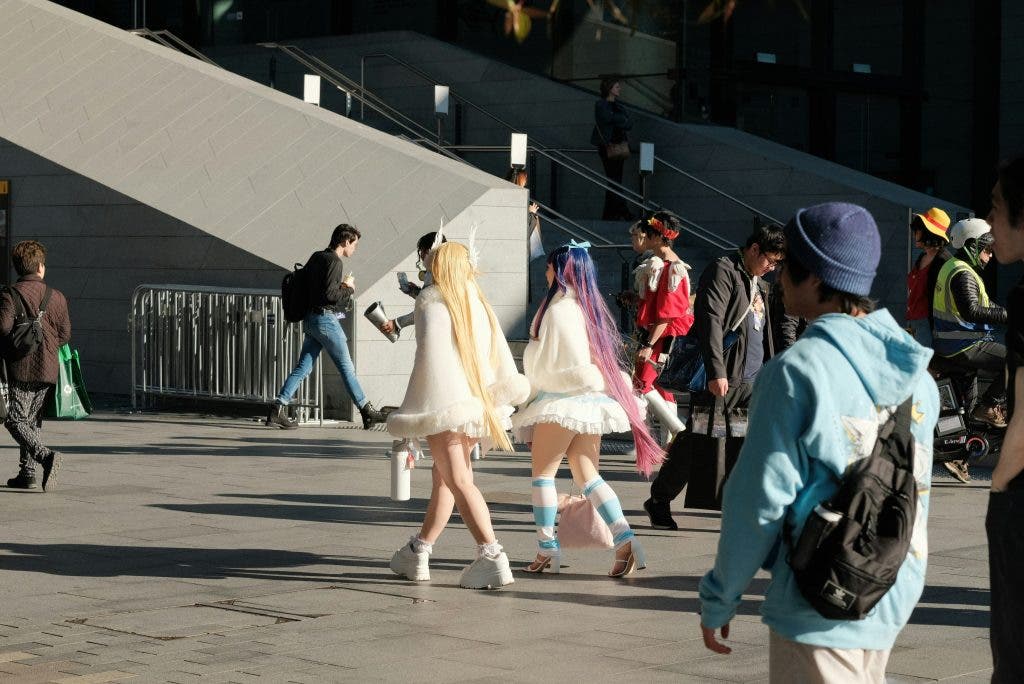 two cosplayers walking alongside each other wearing white dresses