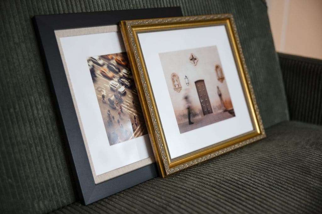Two framed photos resting on a couch