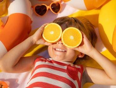 a photograph of kid sunbathing at the beach in the summer