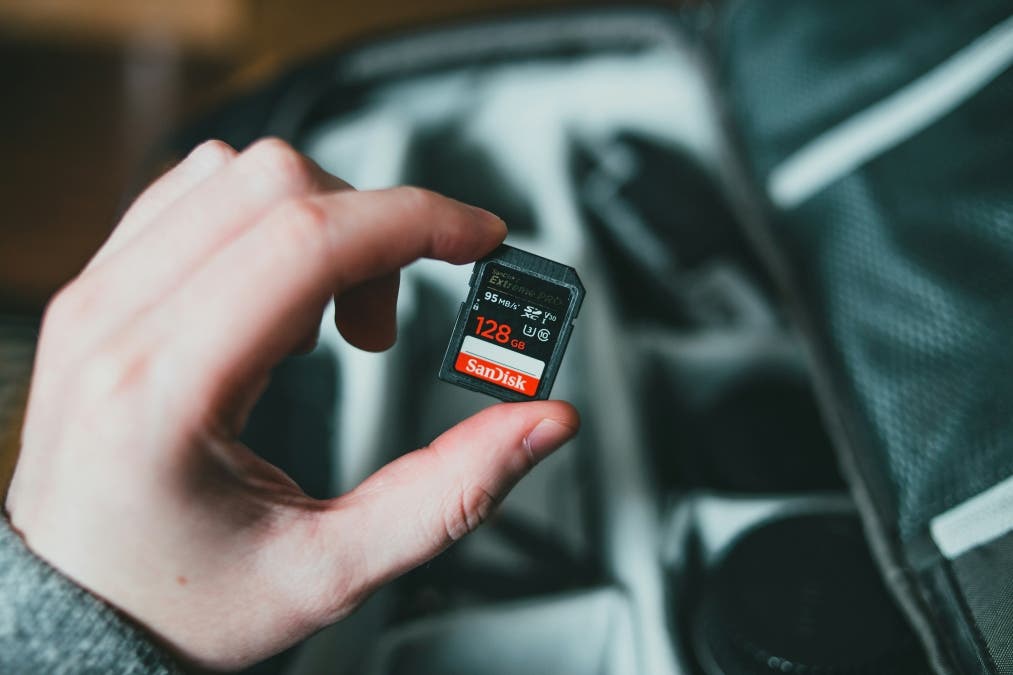 man holds SD card before he places it in his photography gear kit