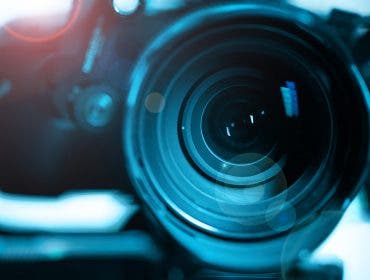 Close-up of modern black mirrorless digital video camera on stabilizer. Cinematic equipment concept.