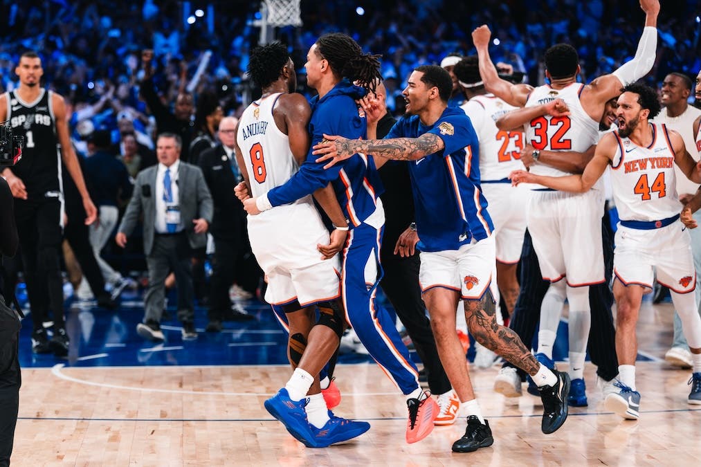 New York Knicks players, including OG Anunoby and Karl-Anthony Towns, wildly celebrate on the court against the San Antonio Spurs during the NBA Finals
